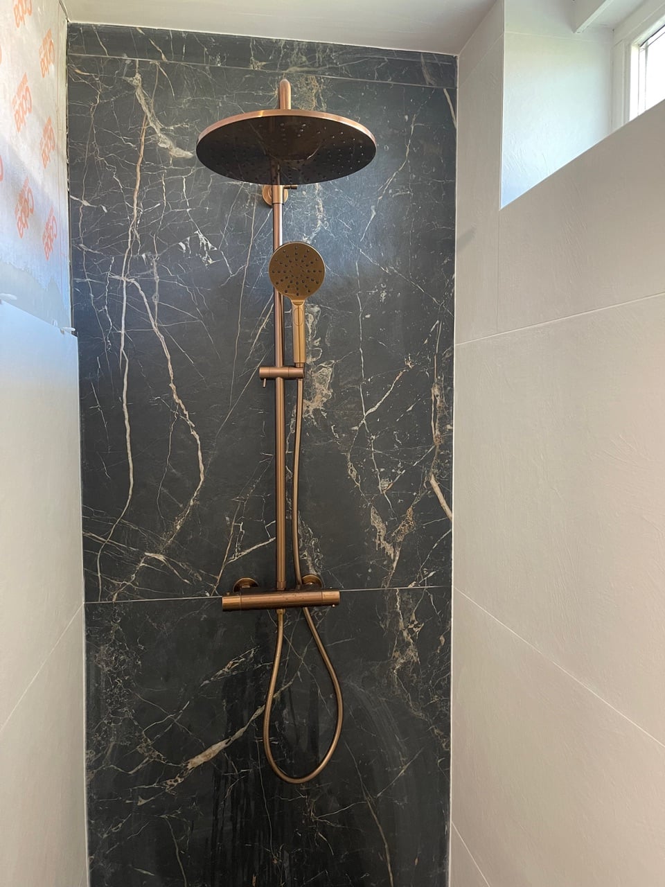 Rosé gouden regendouche op donker marmer